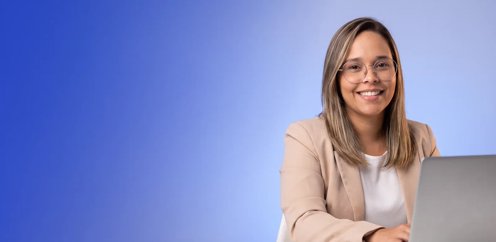 Empresária sorrindo enquanto trabalha no notebook